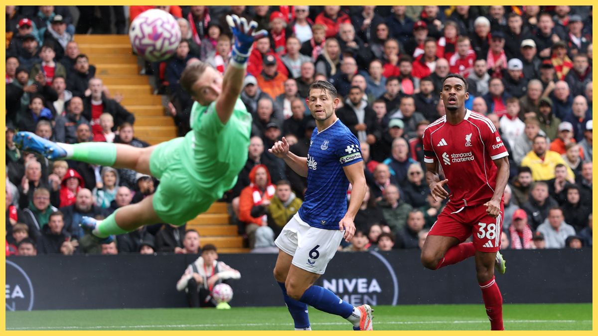 Ryan Gravenberch of Liverpool scores his team's first goal past goalkeeper Jordan Pickford of Everton as James Tarkowski looks on during the Premier League match between Liverpool and Everton at Anfield
