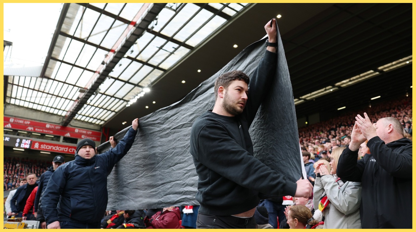 Liverpool fans prepare to unfurl a banner objecting to ticket price increases at Anfield