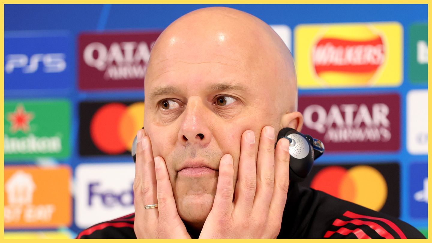 Liverpool manager Arne Slot holds his face in hands.