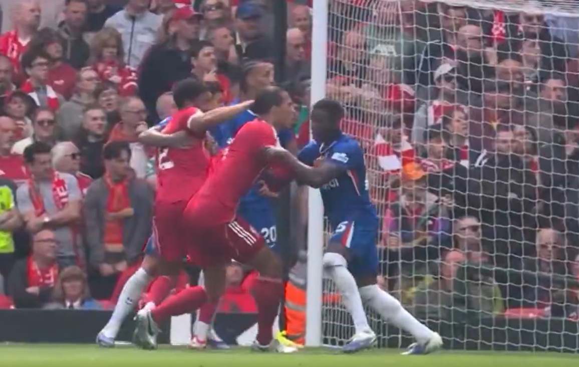 Liverpool captain Virgil van Dijk is held by Moises Caicedo as a corner kick comes into the penalty area