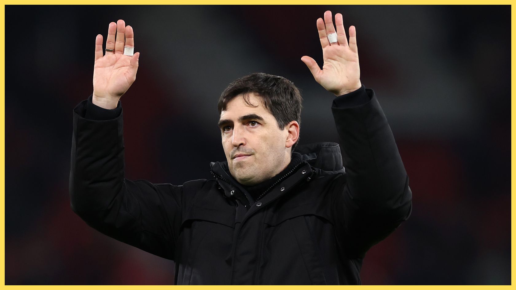 Liverpool manager Andoni Iraola holds his hands up in the air.