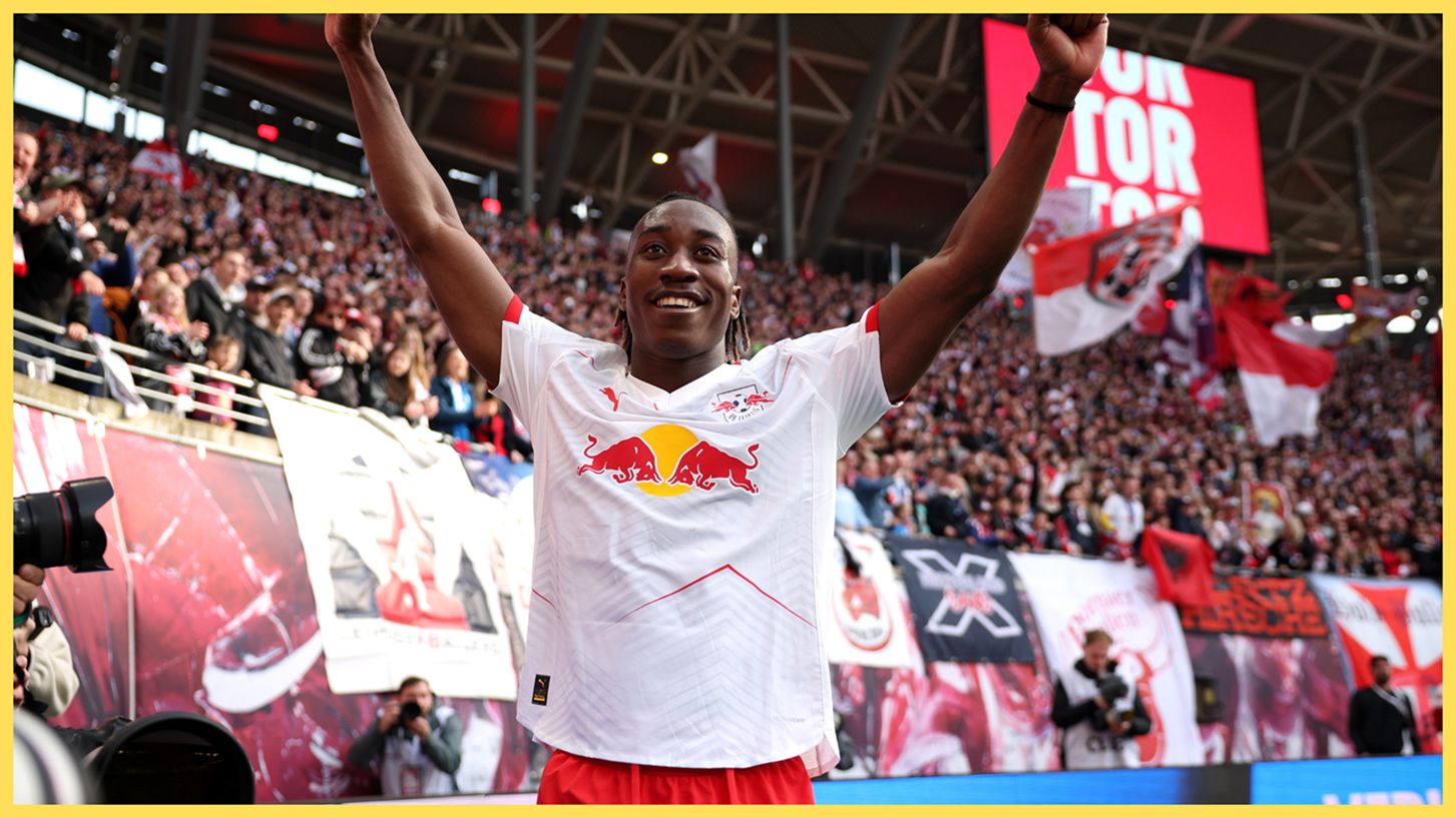 Liverpool transfer target Yan Diomande throws his arms in the air in celebration.