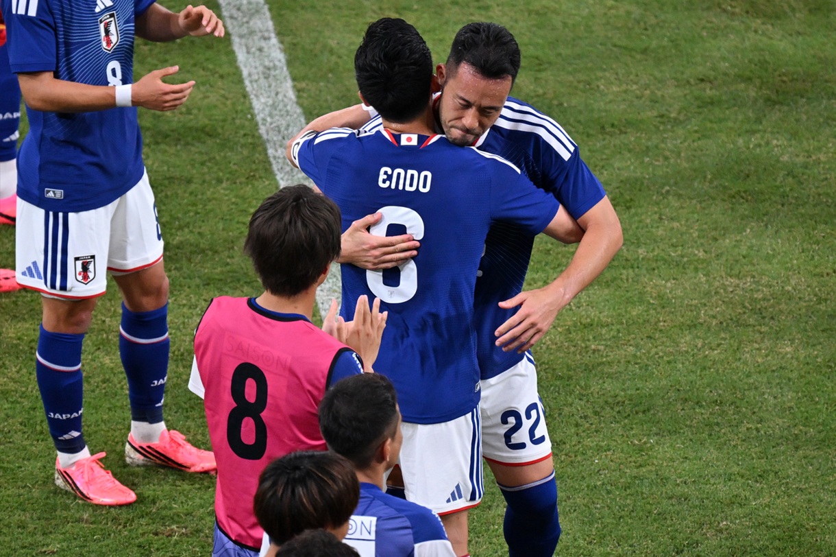 Wataru Endo hugs Maya Yoshida during a match for Japan