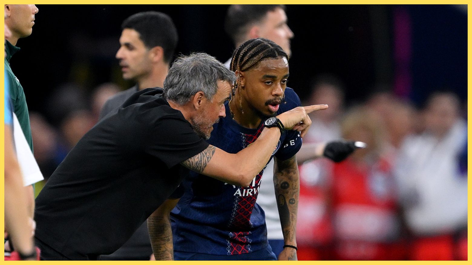 PSG head coach Luis Enrique gestures at the pitch while in conversation with Liverpool transfer target Bradley Barcola.