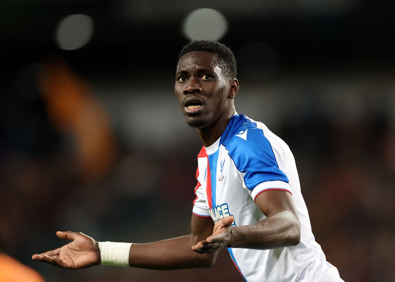 Ismaila Sarr holds out his arms with a surprised expression.