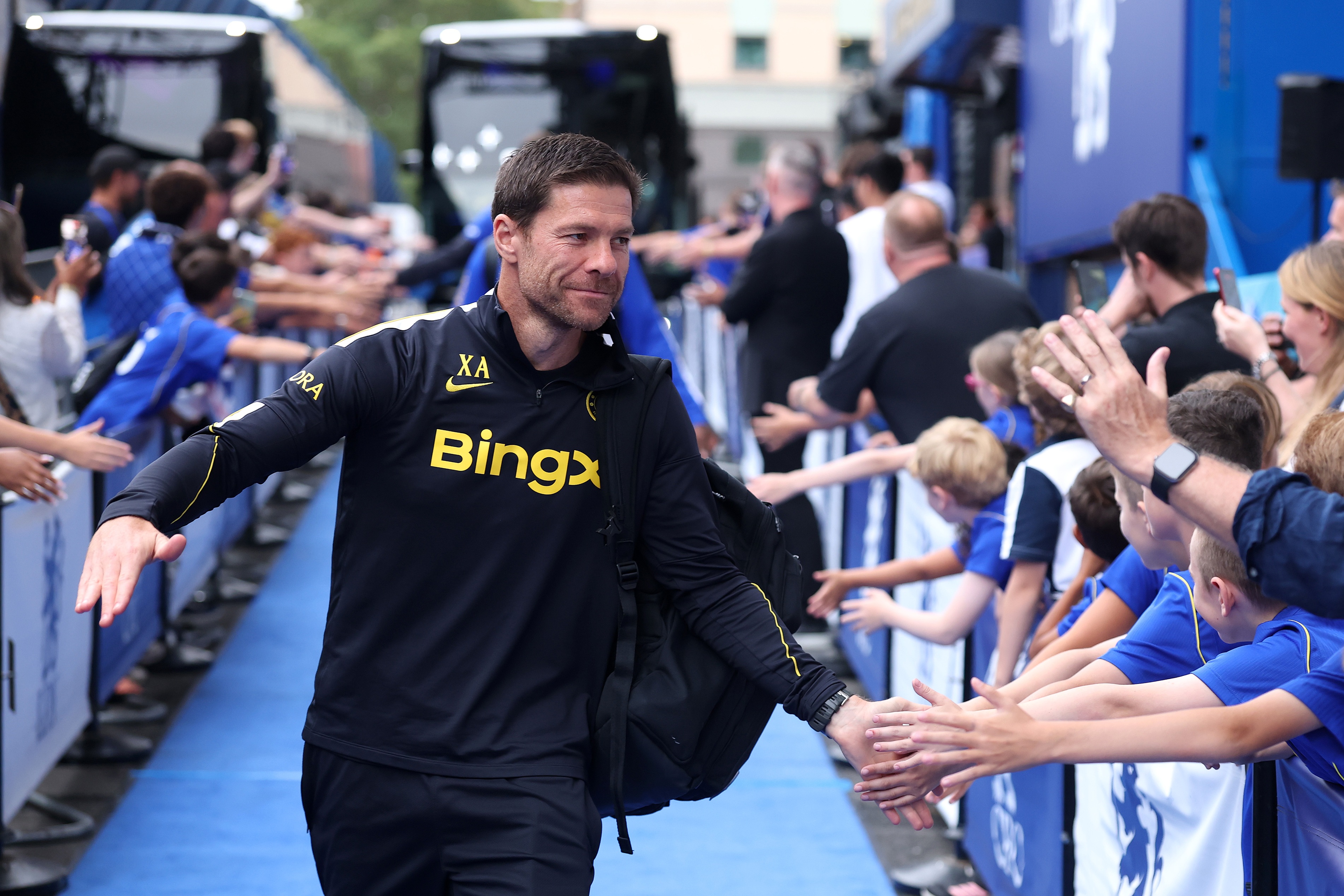 Chelsea manager Xabi Alonso high fives Chelsea fans outside of Stamford Bridge.