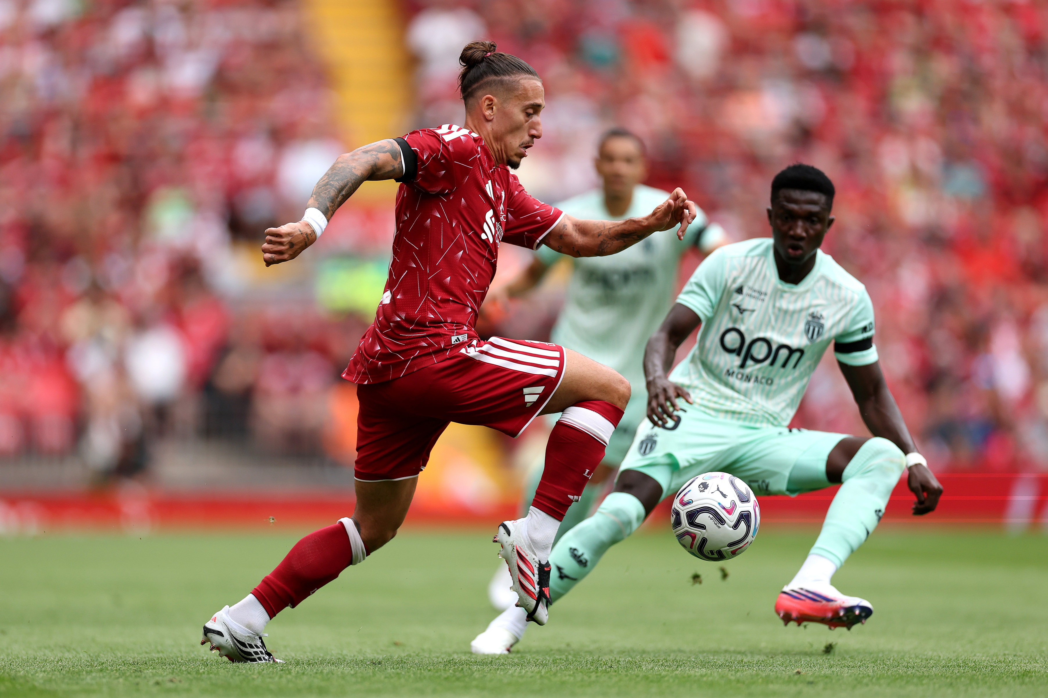 Lamine Camara defends against Kostas Tsimikas during Liverpool game.