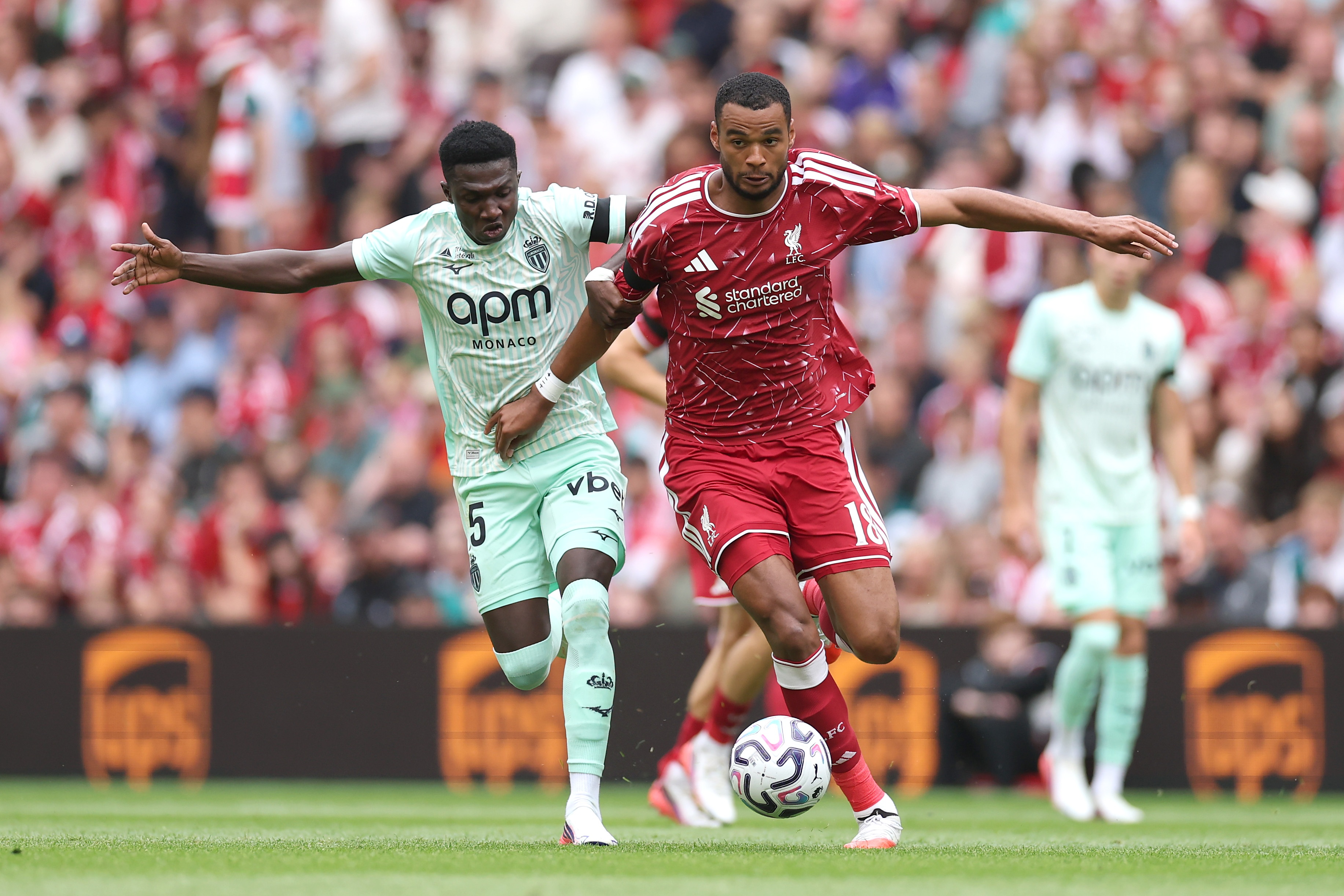 Liverpool transfer target Lamine Camara battles Cody Gakpo for possession of the ball.