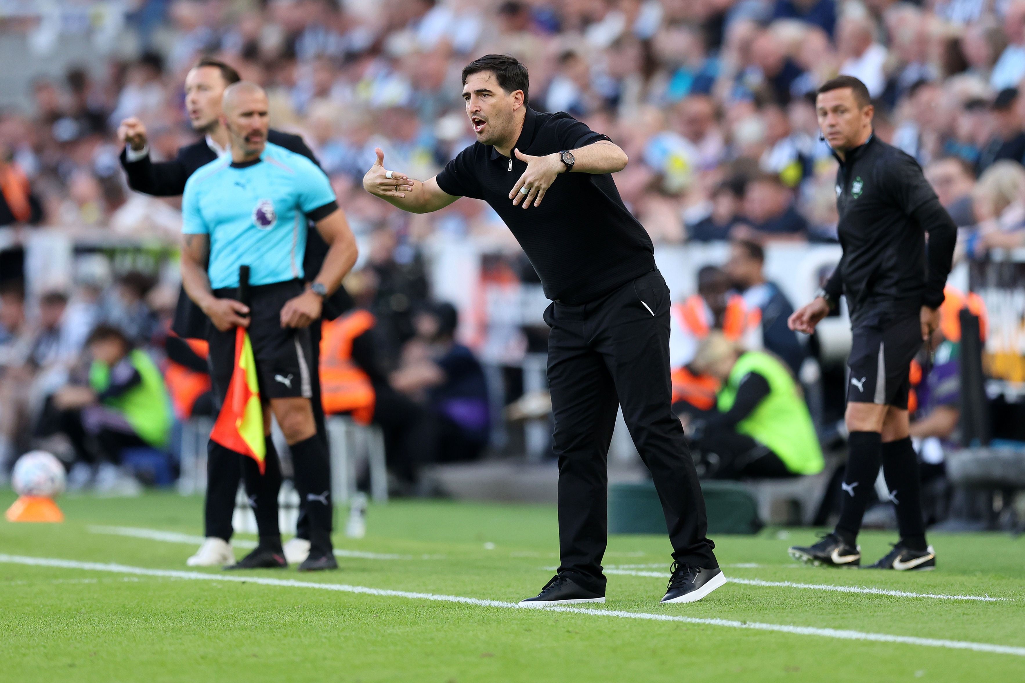 Liverpool manager Andoni Iraola gestures at his players from the touchline.