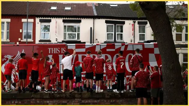 Liverpool fans get a glimpse of the team bus as it passes