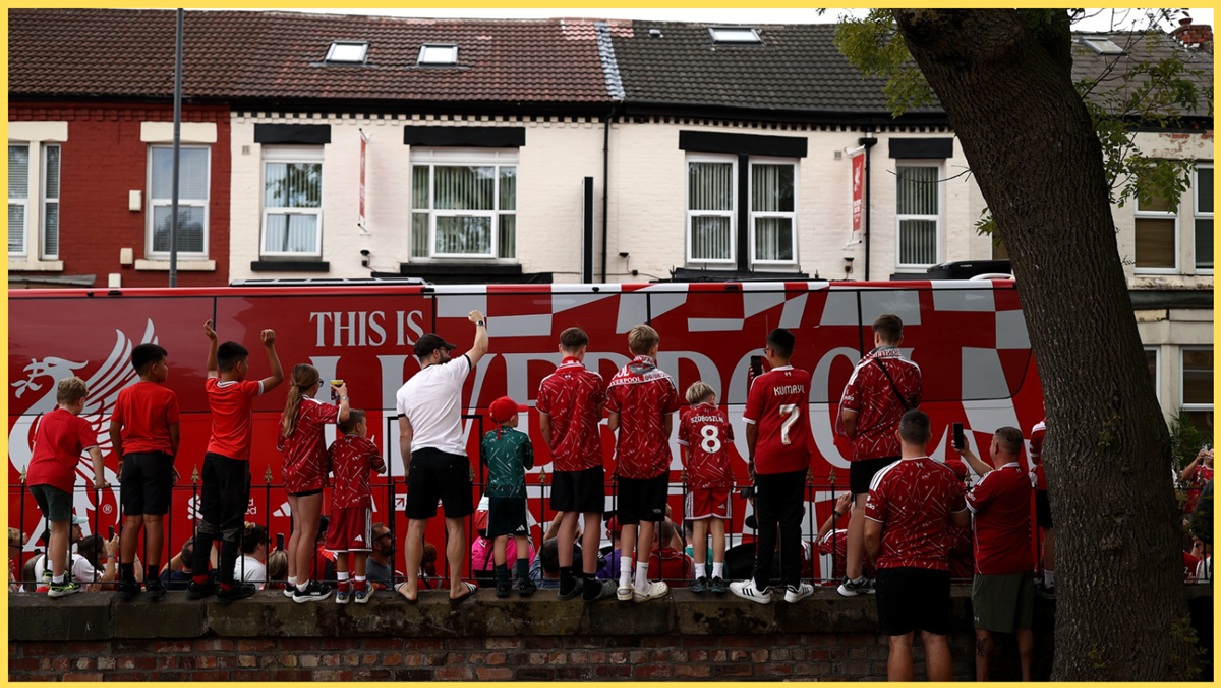Liverpool fans get a glimpse of the team bus as it passes