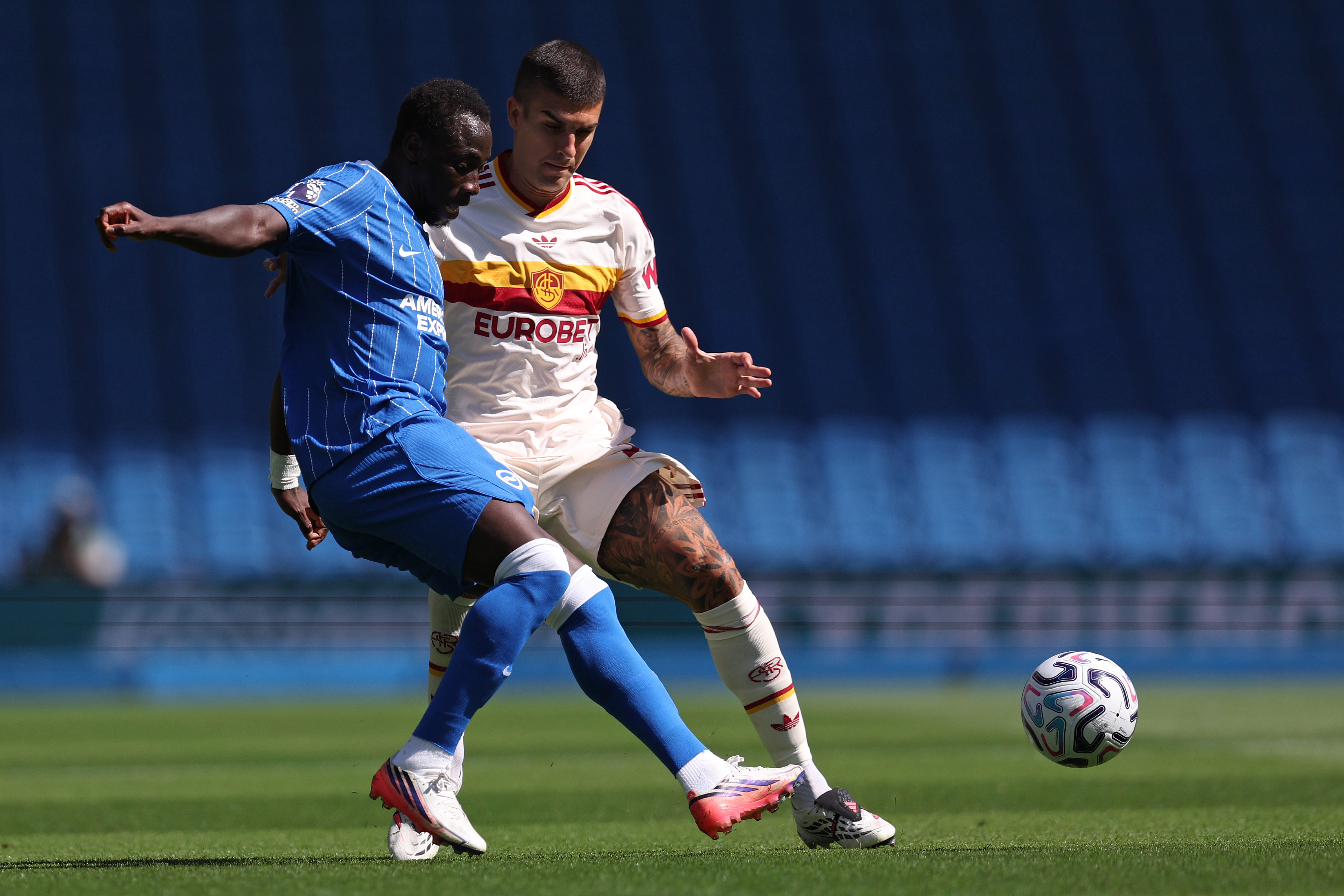 Yankuna Minteh gets to the ball ahead of Gianluca Mancini