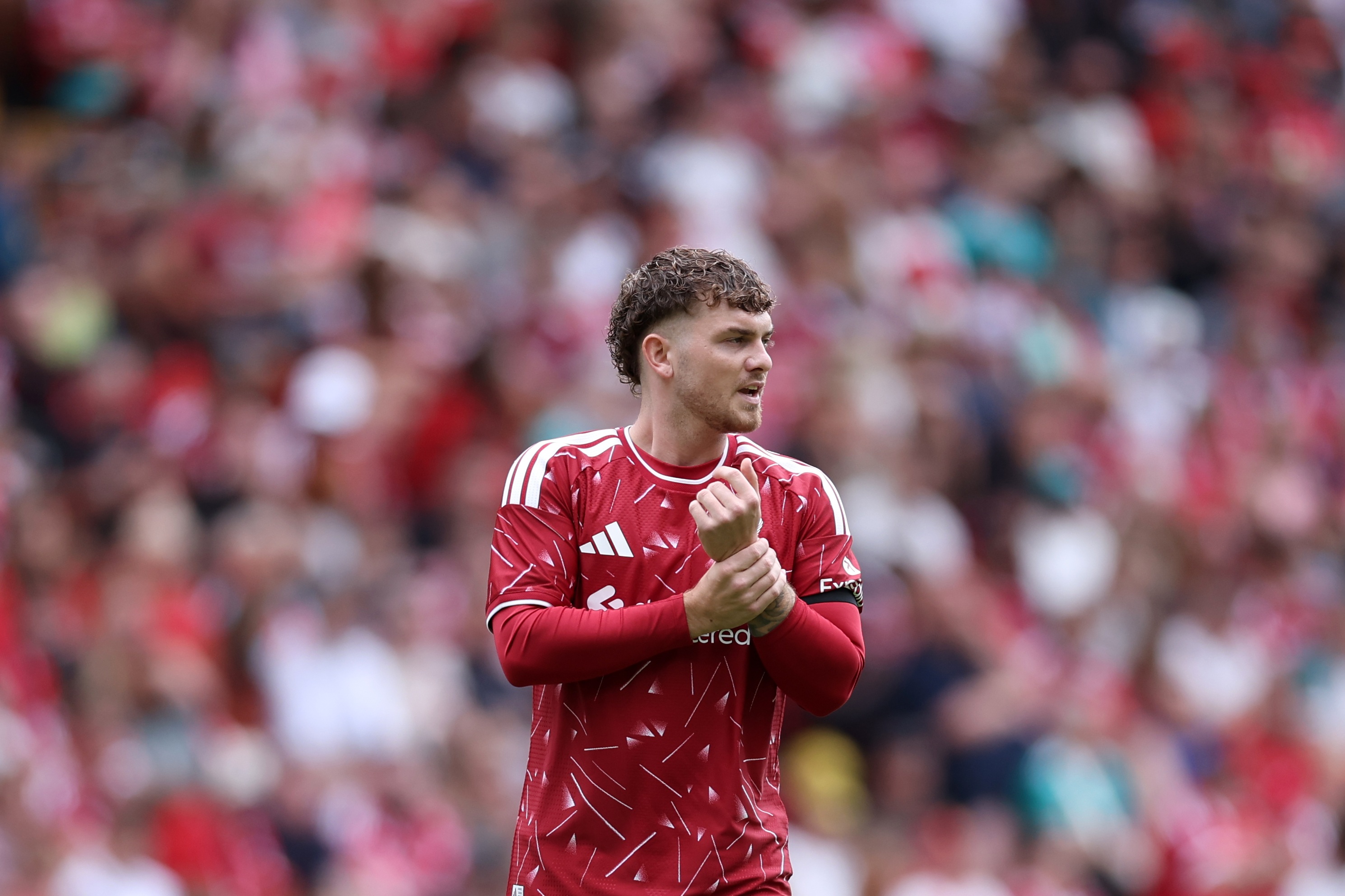 Harvey Elliott grabs his wrist during Liverpool game.