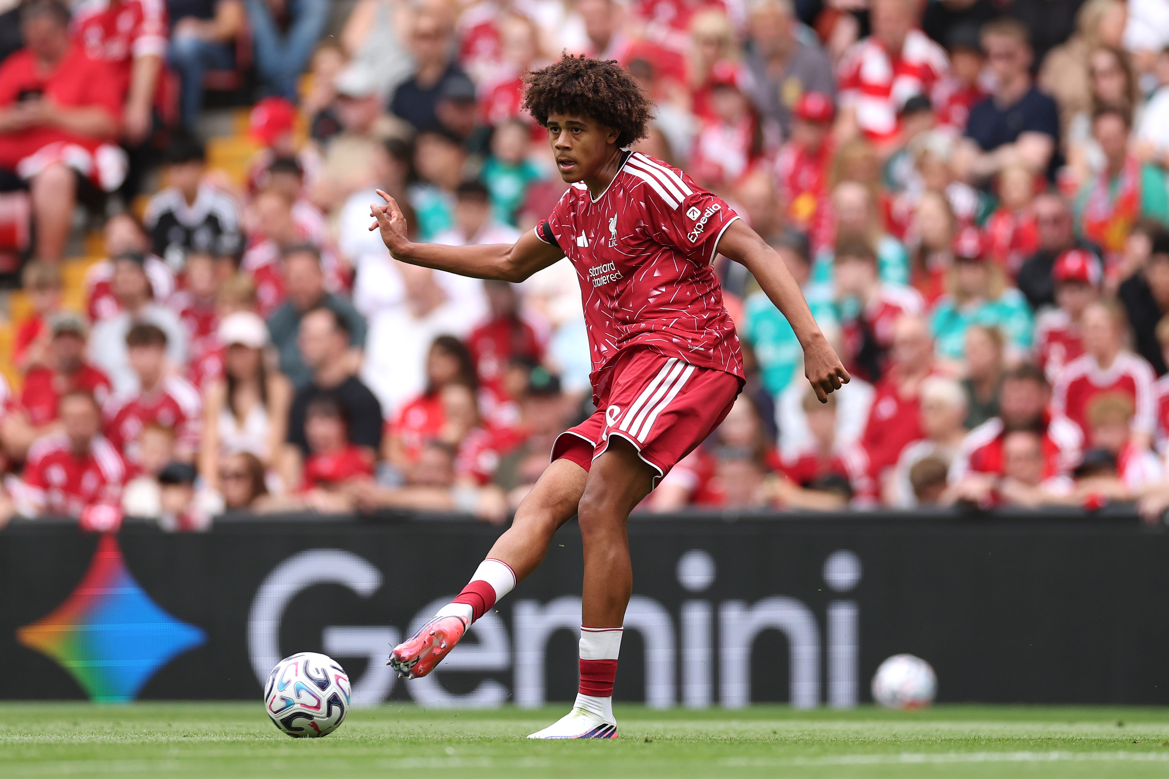 Liverpool centre-back Ifeanyi Ndukwe plays a pass in front of fans.