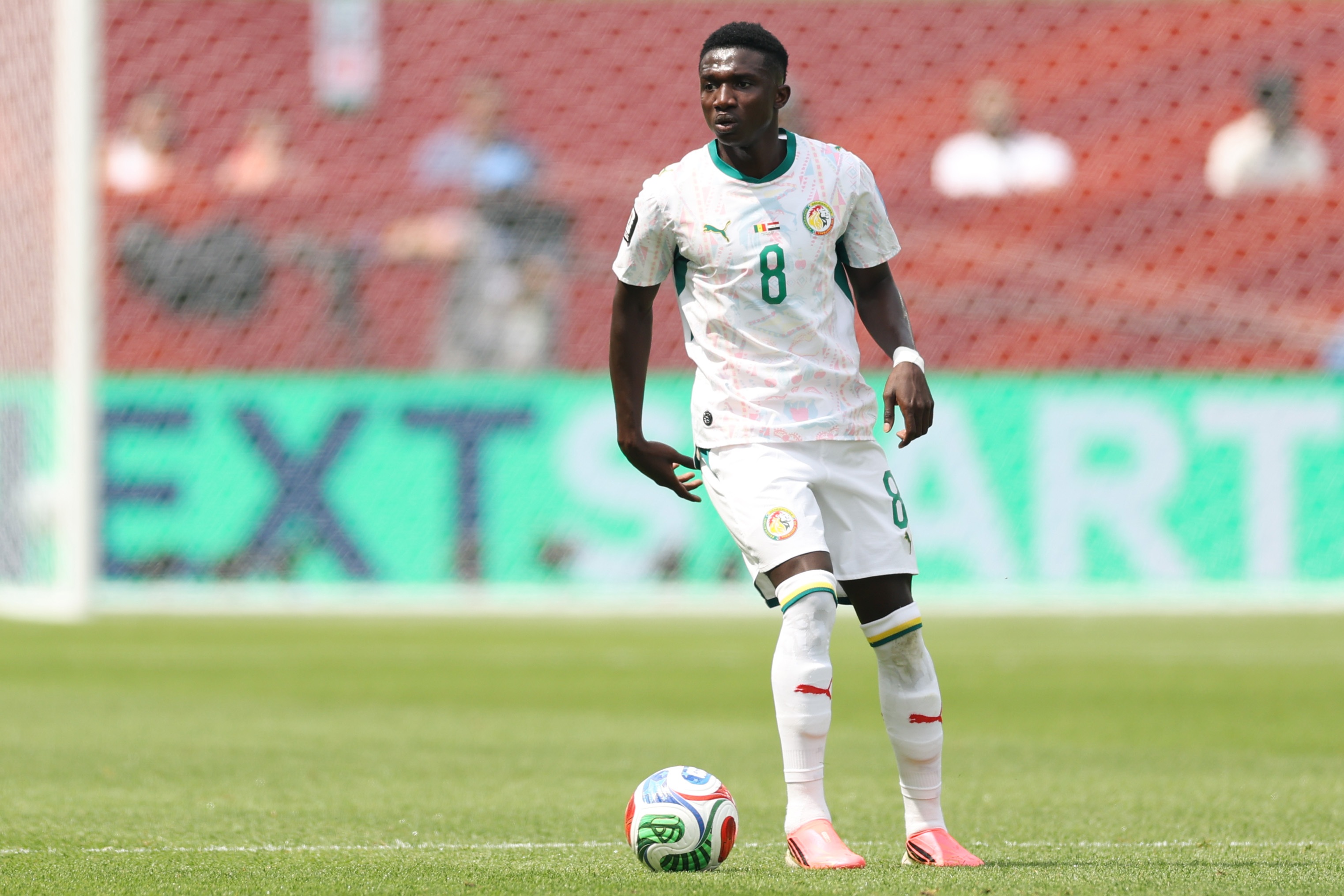 Liverpool transfer target Lamine Camara dribbles on the ball during Senegal game.