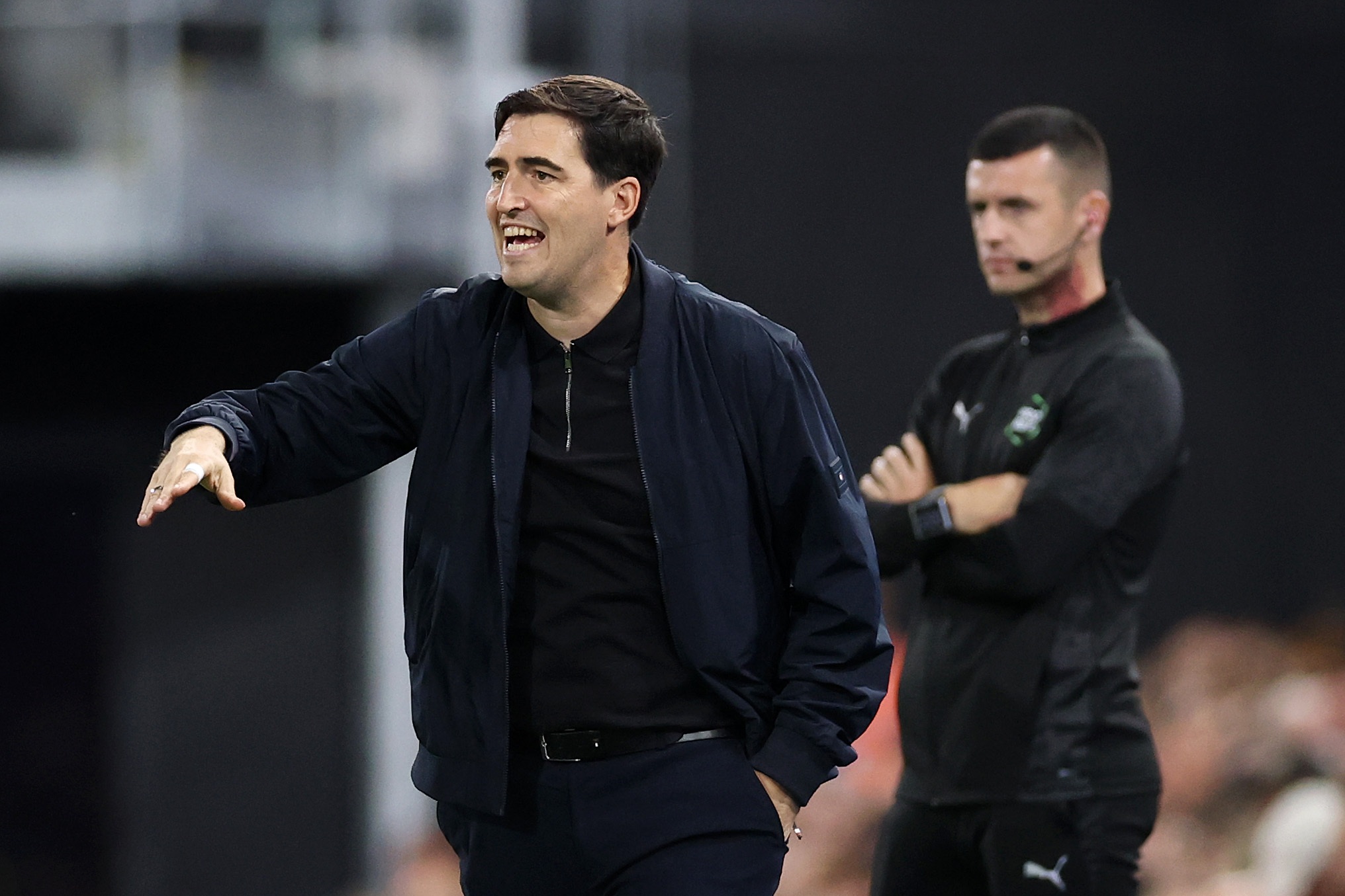 Liverpool manager Andoni Iraola, dressed all in black, gestures from the touchline.