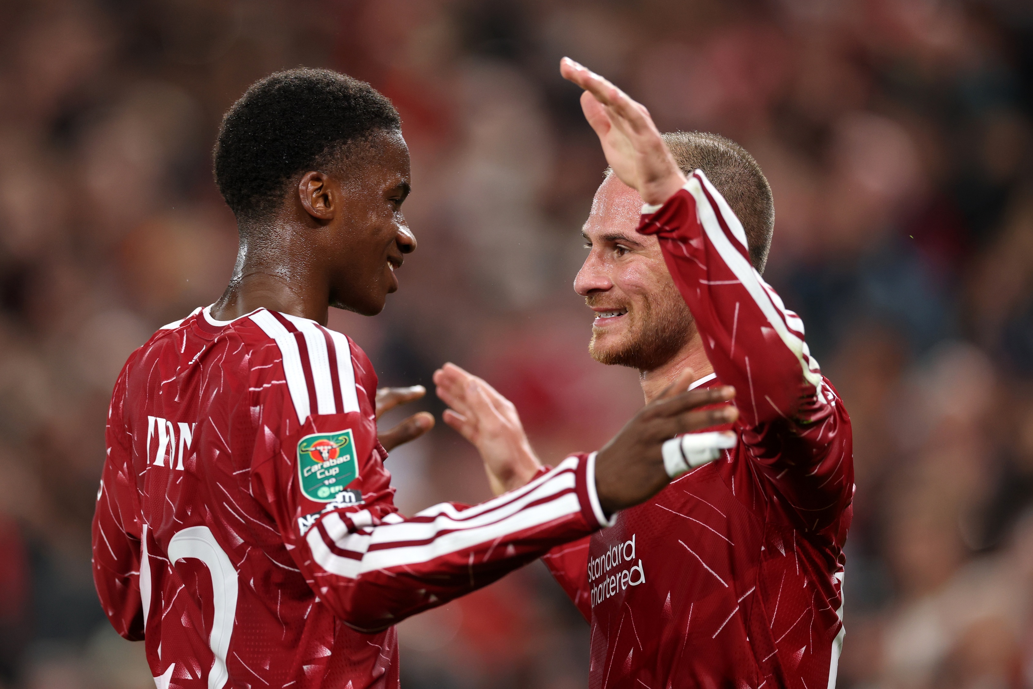 Liverpool midfielders Trey Nyoni and Alexis Mac Allister hug on the pitch.